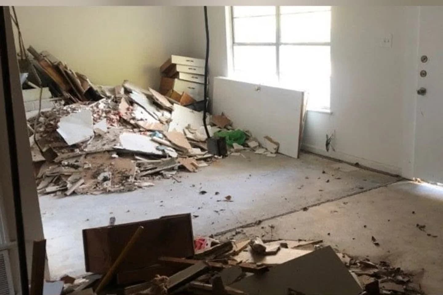 Interior room filled with demolition debris before cleanup